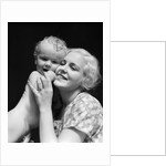 1930s blonde woman mother smiling holding baby to cheek by Anonymous