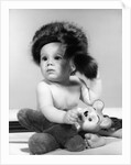 1960s baby wearing coonskin hat by Anonymous