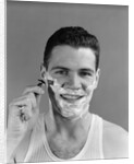 1940s smiling man shaving wearing tee shirt by Anonymous