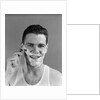 1940s smiling man shaving wearing tee shirt by Anonymous