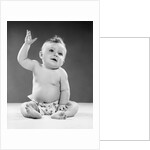1950s portrait of baby sitting one arm raised waving by Anonymous