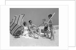 1960s at the beach two boys with baseball bat trying to pull up father seated next to mother so he will play with them by Anonymous
