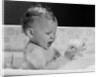 1960s baby in bathtub playing with suds indoor by Anonymous