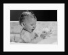 1960s baby in bathtub playing with suds indoor by Anonymous