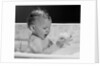 1960s baby in bathtub playing with suds indoor by Anonymous