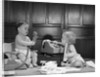 1960s 2 babies in diapers one on chair with telephone other on floor with adding machine pencil behind ear by Anonymous