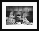 1960s 2 babies in diapers one on chair with telephone other on floor with adding machine pencil behind ear by Anonymous