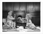 1960s 2 babies in diapers one on chair with telephone other on floor with adding machine pencil behind ear by Anonymous