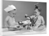1960s two babies playing doctor and nurse with doll studio by Anonymous