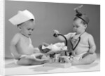 1960s two babies playing doctor and nurse with doll studio by Anonymous