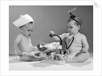 1960s two babies playing doctor and nurse with doll studio by Anonymous