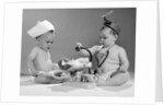 1960s two babies playing doctor and nurse with doll studio by Anonymous