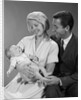 1960s happy mother and father smiling at their baby by Anonymous