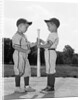 1960s two boys in baseball uniforms choosing sides by getting the upper hand on a bat by Anonymous