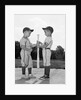 1960s two boys in baseball uniforms choosing sides by getting the upper hand on a bat by Anonymous
