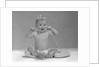 1960s blond baby sitting up looking at camera chewing on telephone cord by Anonymous