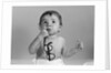 1960s baby in diaper chewing on eyeglasses by Anonymous