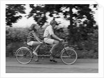 1970s teenage girl and boy riding bicycle built for two by Anonymous