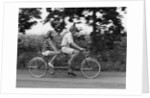 1970s teenage girl and boy riding bicycle built for two by Anonymous