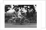 1970s teenage girl and boy riding bicycle built for two by Anonymous
