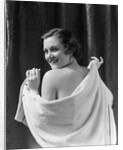 1930s smiling brunette woman looking over shoulder drying back with towel looking at camera by Anonymous