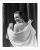 1930s smiling brunette woman looking over shoulder drying back with towel looking at camera by Anonymous