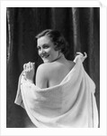 1930s smiling brunette woman looking over shoulder drying back with towel looking at camera by Anonymous