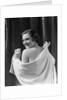 1930s smiling brunette woman looking over shoulder drying back with towel looking at camera by Anonymous