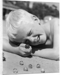 Boy crouching shooting marbles concentration by Anonymous