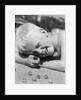 Boy crouching shooting marbles concentration by Anonymous