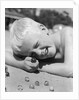 Boy crouching shooting marbles concentration by Anonymous