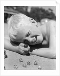 Boy crouching shooting marbles concentration by Anonymous