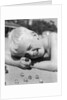Boy crouching shooting marbles concentration by Anonymous