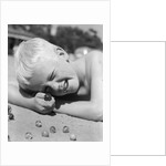 Boy crouching shooting marbles concentration by Anonymous