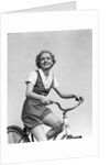 1930s smiling blonde woman riding bicycle looking at camera by Anonymous