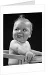 1950s 1940s baby in high chair head turned to one side with tongue sticking out funny facial expression by Anonymous