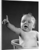 1940s 1950s baby sitting in chair arm and one finger raised objecting voting making a point looking at camera by Anonymous