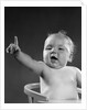 1940s 1950s baby sitting in chair arm and one finger raised objecting voting making a point looking at camera by Anonymous