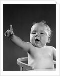 1940s 1950s baby sitting in chair arm and one finger raised objecting voting making a point looking at camera by Anonymous