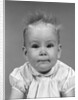 1960s head on portrait of baby girl in ruffled dress straight up hair looking at camera by Anonymous