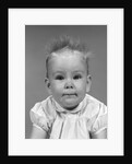 1960s head on portrait of baby girl in ruffled dress straight up hair looking at camera by Anonymous