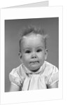 1960s head on portrait of baby girl in ruffled dress straight up hair looking at camera by Anonymous