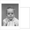 1960s head on portrait of baby girl in ruffled dress straight up hair looking at camera by Anonymous