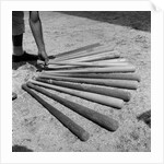 1950s baseball player selecting from a variety of bats by Anonymous
