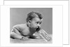 1950s baby sitting leaning forward drinking from bottle studio indoor by Anonymous
