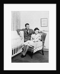 1930s 1940s mother sitting in chair in nursery baby 11 months on lap drinking from bottle father looking on leaning on crib by Anonymous