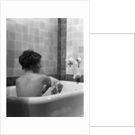 1920s 1930s young brunette woman sitting in luxury bathtub taking a bath by Anonymous