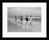1930s four women and one man running on beach holding hands by Anonymous
