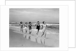 1930s four women and one man running on beach holding hands by Anonymous