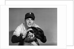 1950s baseball player with glove poised to catch ball keeping his eye on the ball by Anonymous